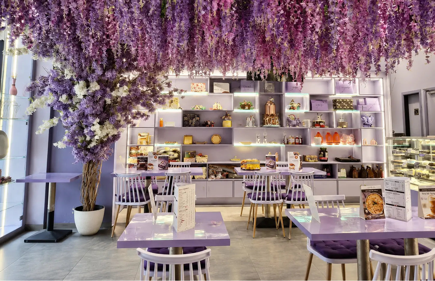 Indoors restaurant with purple floral decorations and tables.