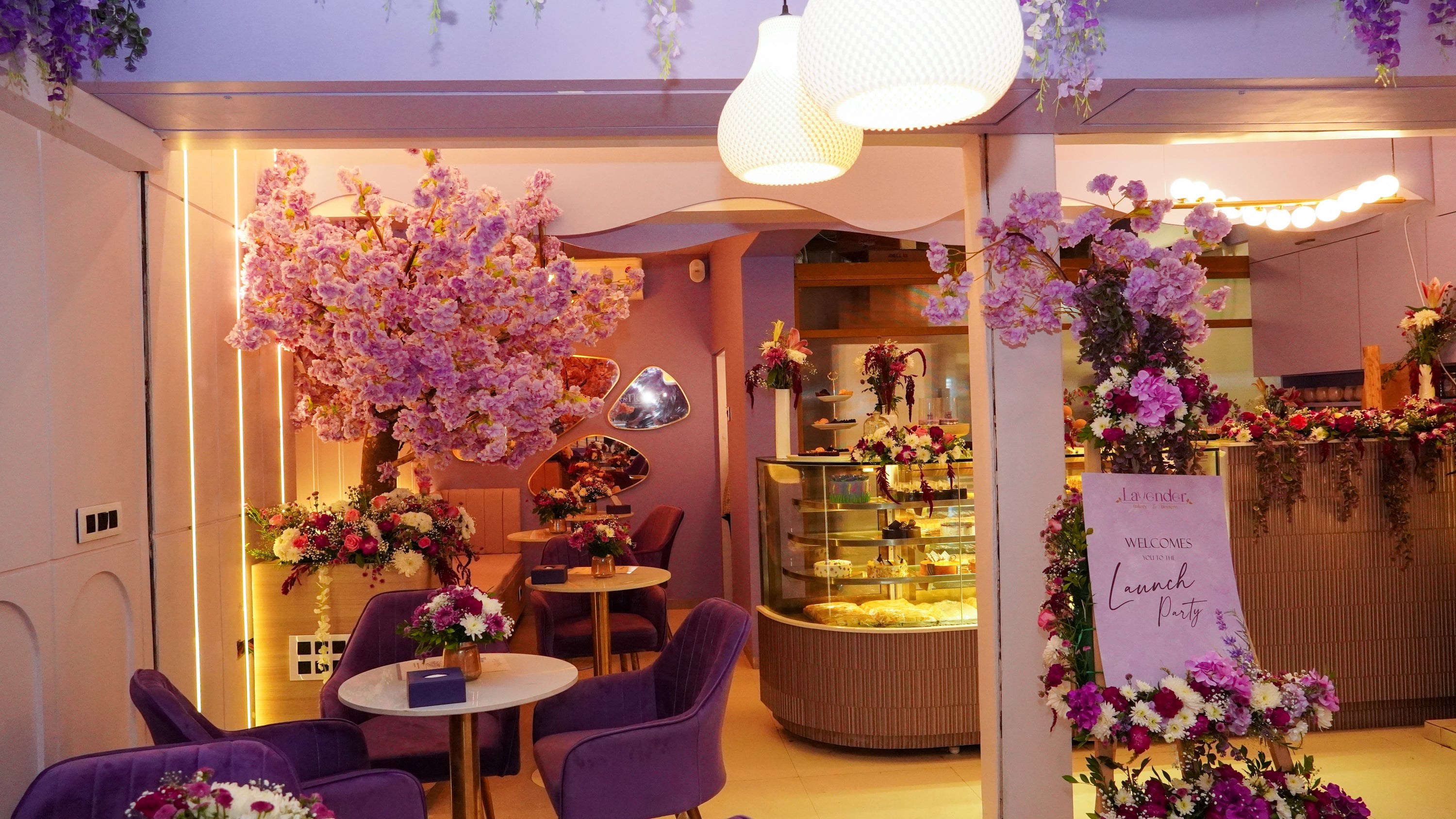 Decorative interior with purple chairs, floral arrangements, and a sign in a restaurant setting.