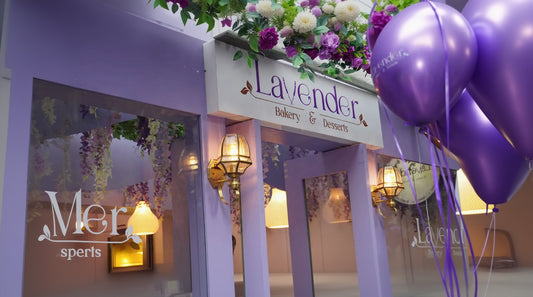 Lavender-themed bakery entrance with decorative lights and balloons.