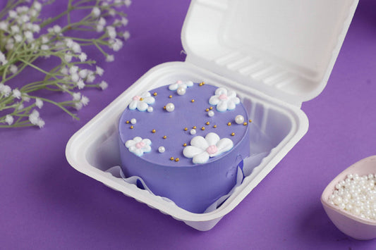 Chocolate Hazelnut Lavender Special Bento Cake with purple frosting and delicate white floral decorations in a bento box.