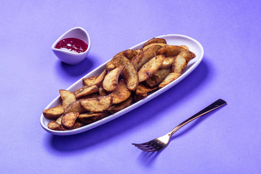 Golden Crispy Potato Wedges served on a platter with a flavourful dipping sauce.