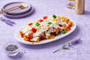 Three Cheese Nachos topped with melted cheese, fresh vegetables and flavourful sauces