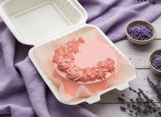 Classic Swiss Chocolate Bento Cake with pink frosting and delicate floral decorations, presented in a white bento box.